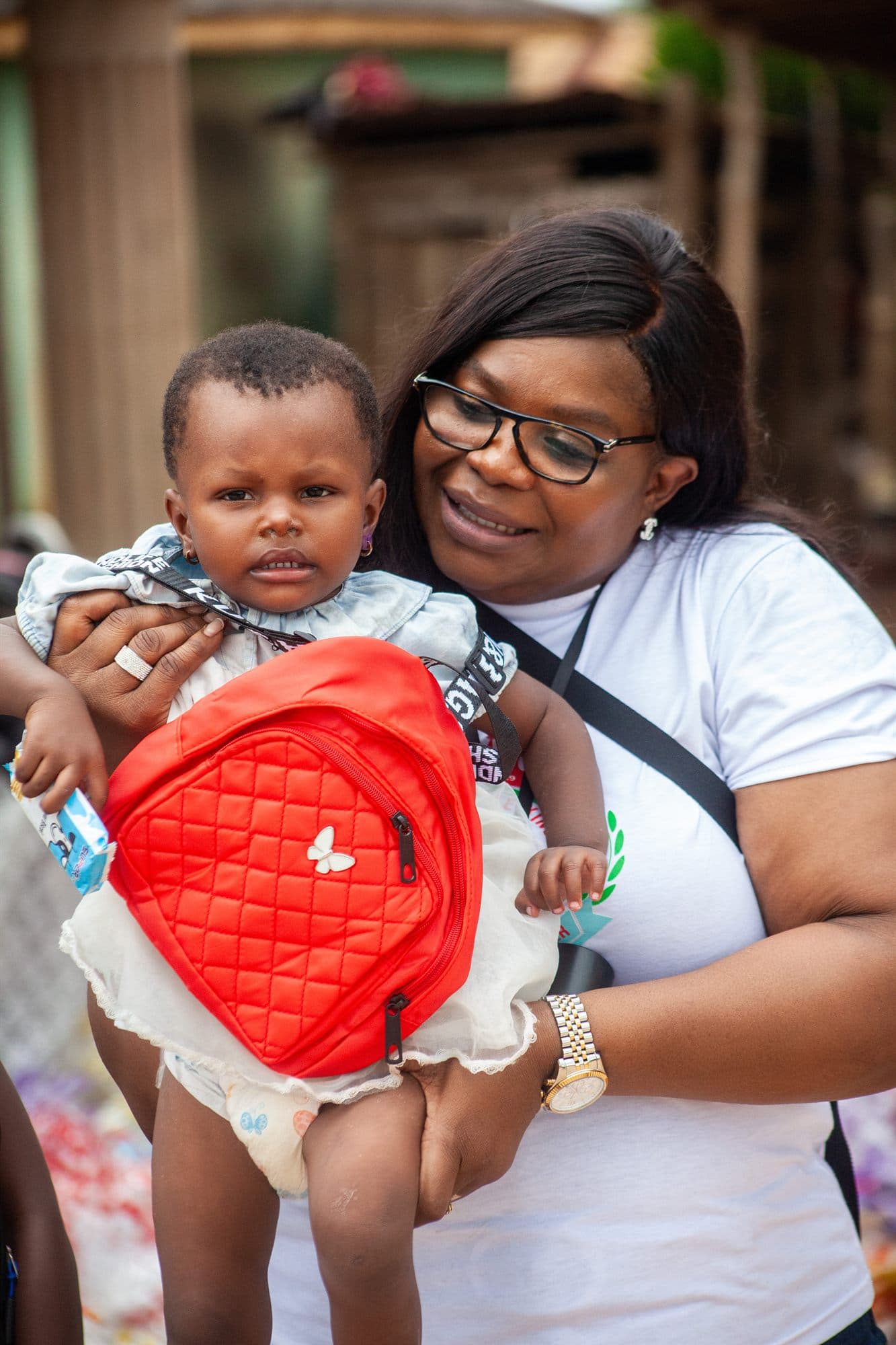 A Women of the Kingdom volunteer holding a baby at a community outreach