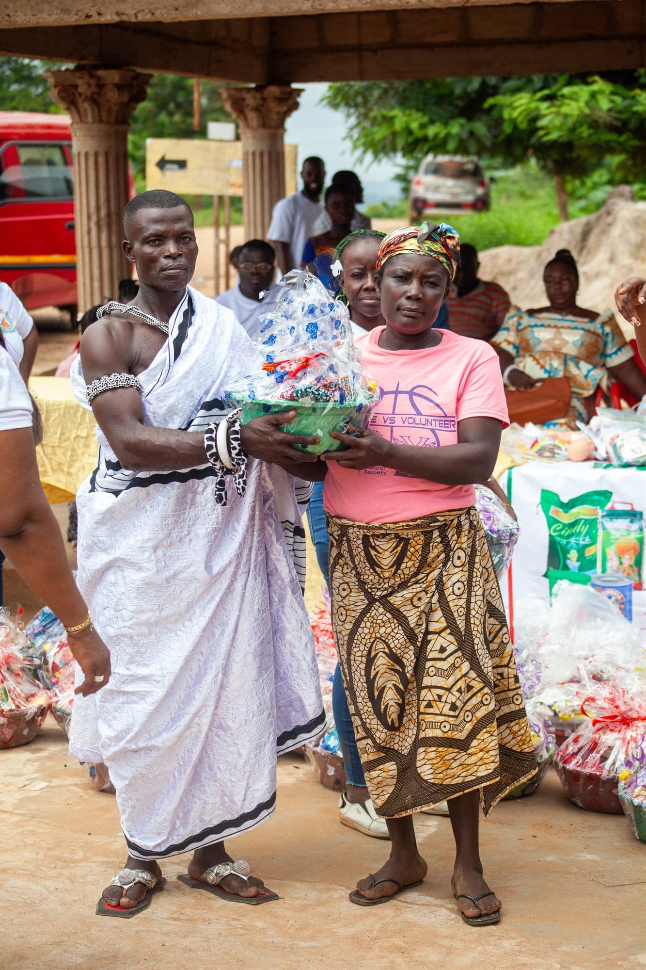 An elderly woman receiving a wrapped gift hamper