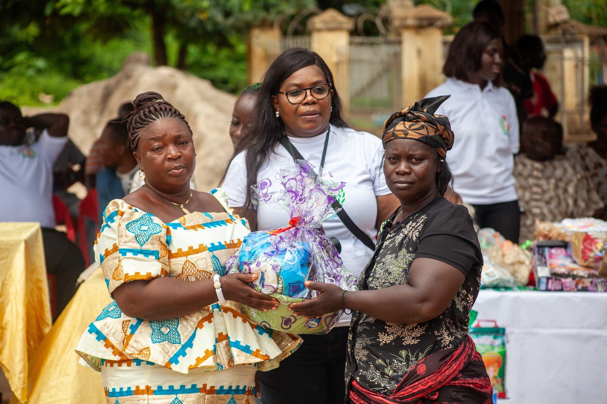 A volunteer presenting a gift hamper to a community elder