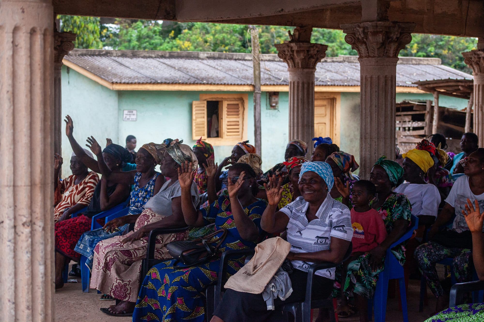 Community members gathered together under a pavilion at an outreach