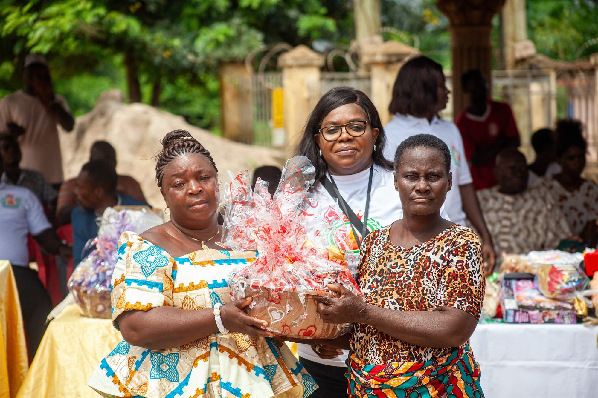 A volunteer presenting a wrapped gift hamper to a community member