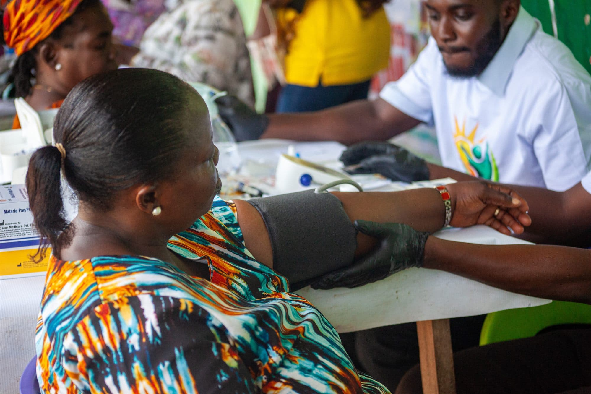 A community member having her blood pressure checked at a health screening
