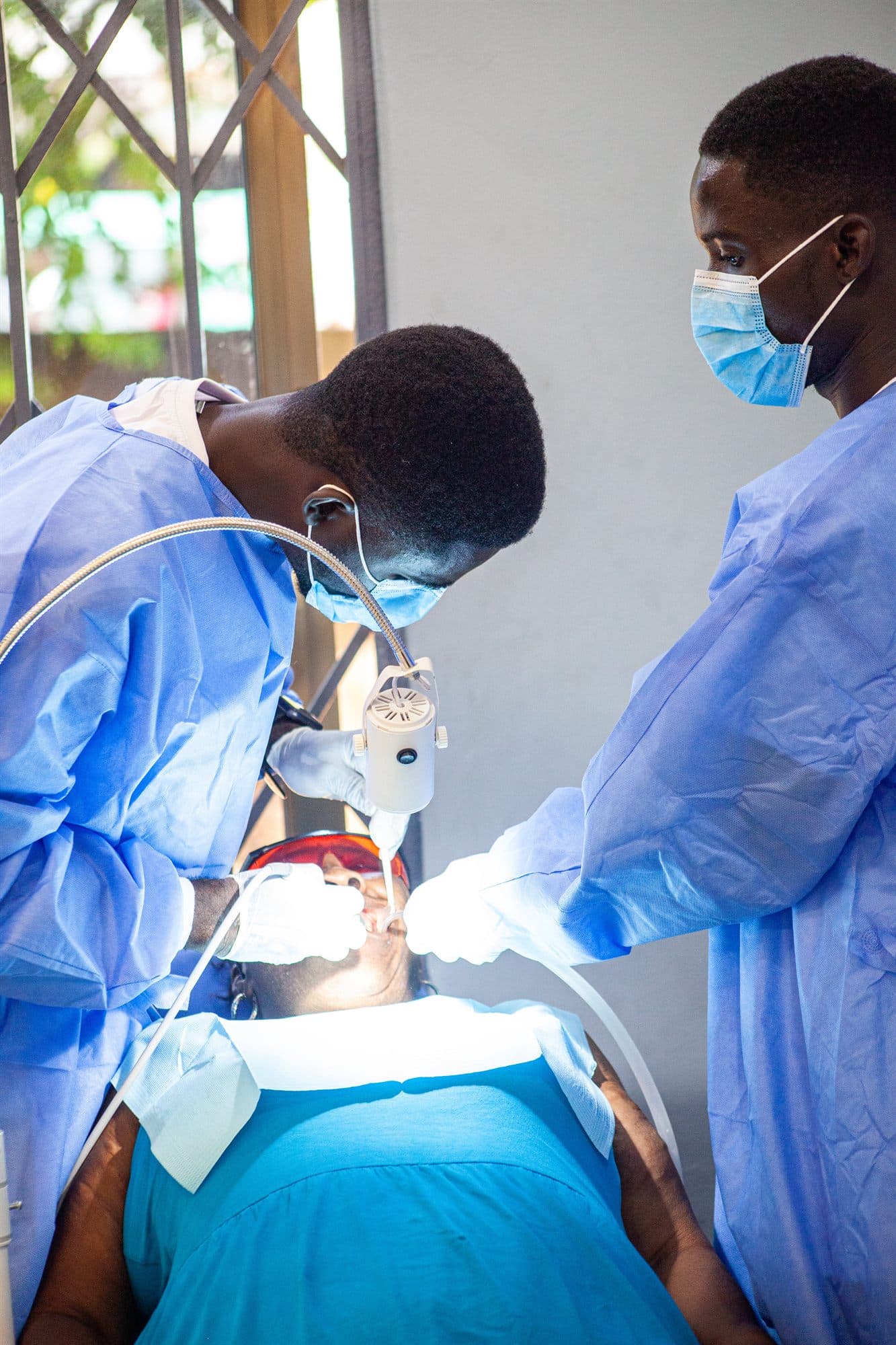 A medic in scrubs attending to a patient at the outreach