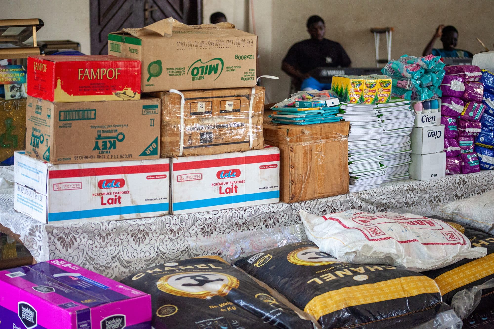 Donated food, toiletries and school supplies stacked on a table ready for distribution